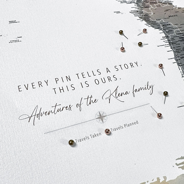 a map with a quote about adventures and family, and there are small pins or beads scattered around the map.