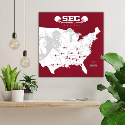 a large map of the United States with various locations marked, and a football player silhouette is depicted on the map. The map is set against a red background with a white border. The room has a shelf with potted plants, and there are hanging light fixtures above the shelf.