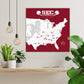 a large map of the United States with various locations marked, and a football player silhouette is depicted on the map. The map is set against a red background with a white border. The room has a shelf with potted plants, and there are hanging light fixtures above the shelf.