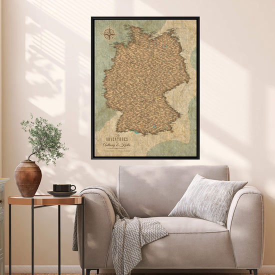 a cozy living room with a large map of Germany hanging on the wall above a gray sofa. The map is framed and appears to be vintage, adding a touch of nostalgia to the room. The sofa is adorned with a throw blanket and a small potted plant, creating a comfortable and inviting atmosphere.