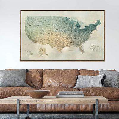 a large framed map of the United States hanging on a wall above a brown leather couch with a wooden coffee table in front of it.