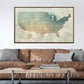 a large framed map of the United States hanging on a wall above a brown leather couch with a wooden coffee table in front of it.