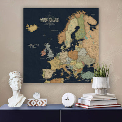 a large map of Europe on a wall, with a bust of a woman and a stack of books placed below it.