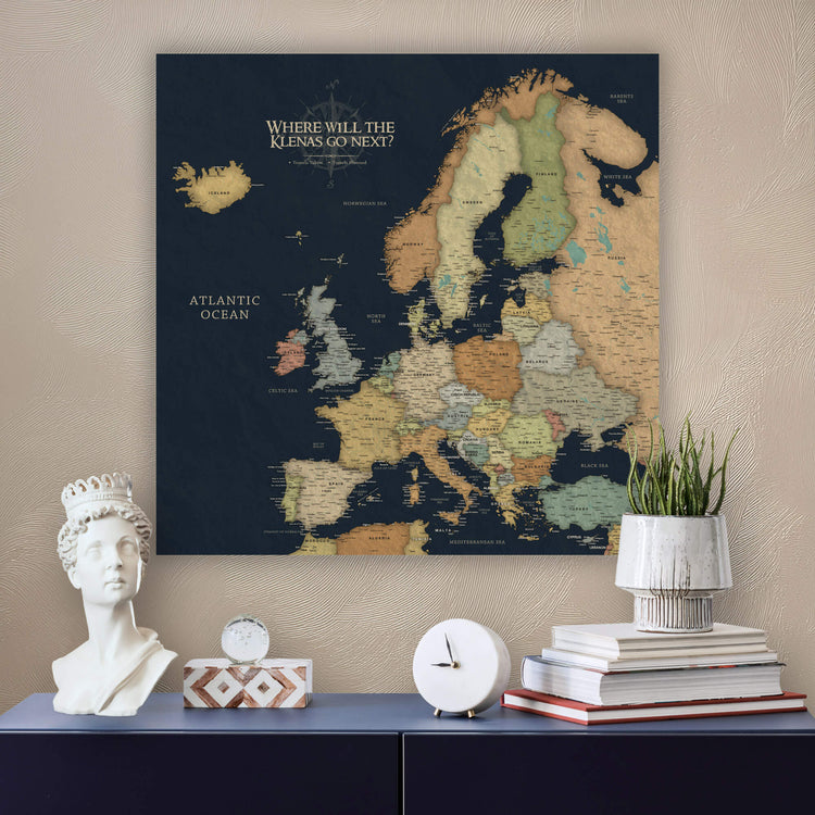 a large map of Europe on a wall, with a bust of a woman and a stack of books placed below it.