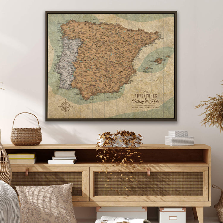 a vintage map of Spain hanging on a wall above a wooden entertainment center with a wicker basket and some books on top.