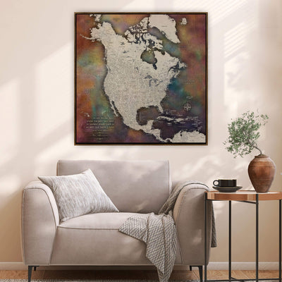 a large, colorful map of North America hanging on a wall above a beige armchair in a cozy living room setting.