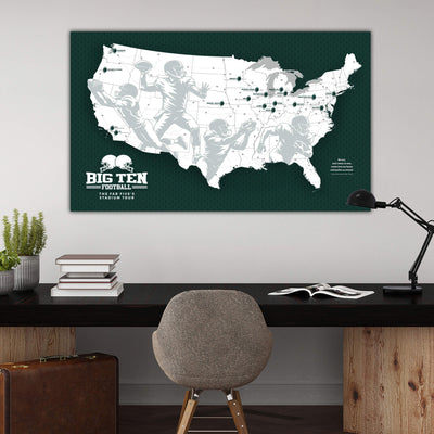 a large map of the United States with silhouettes of football players, representing the Big Ten Football Conference. The map is displayed on a wall above a wooden desk with a chair, a lamp, and some books.