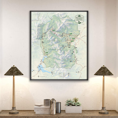 a large framed map of the Yellowstone National Park region hanging on a wall, with two lamps on a shelf below it.