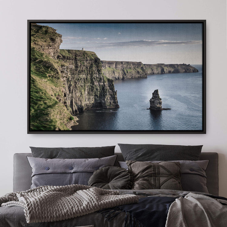 a bed with a blanket and a picture on the wall above it