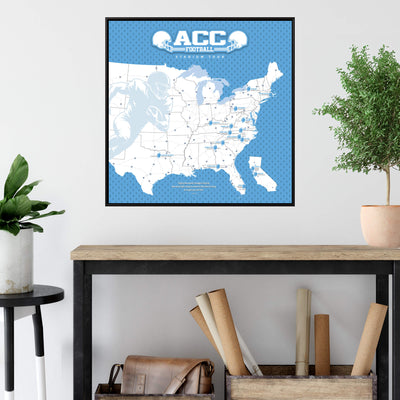 a framed map of the United States with football locations marked, hanging on a wall above a wooden table with various items on it.