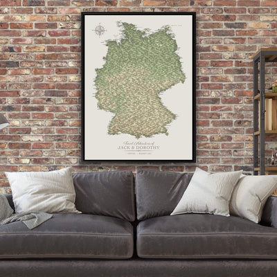 a large map of Germany hanging on a brick wall above a gray couch with white pillows.