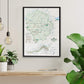 a framed map of Yosemite National Park hanging on a wall, with a wooden shelf below it and potted plants to the left and right.