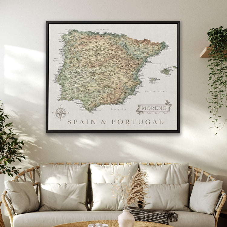 a large framed map of Spain and Portugal hanging on a wall above a couch in a living room.