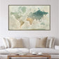 a large world map hanging on a wall above a white couch with beige pillows.