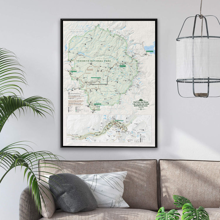 a framed map of Yosemite National Park hanging on a wall, with a couch and a potted plant in the foreground.