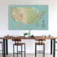 a large map of the United States displayed on a wall above a wooden dining table with chairs.