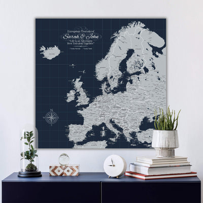 a large map of Europe on a wall, with a glass dome containing a plant and a stack of books on a blue shelf below it.