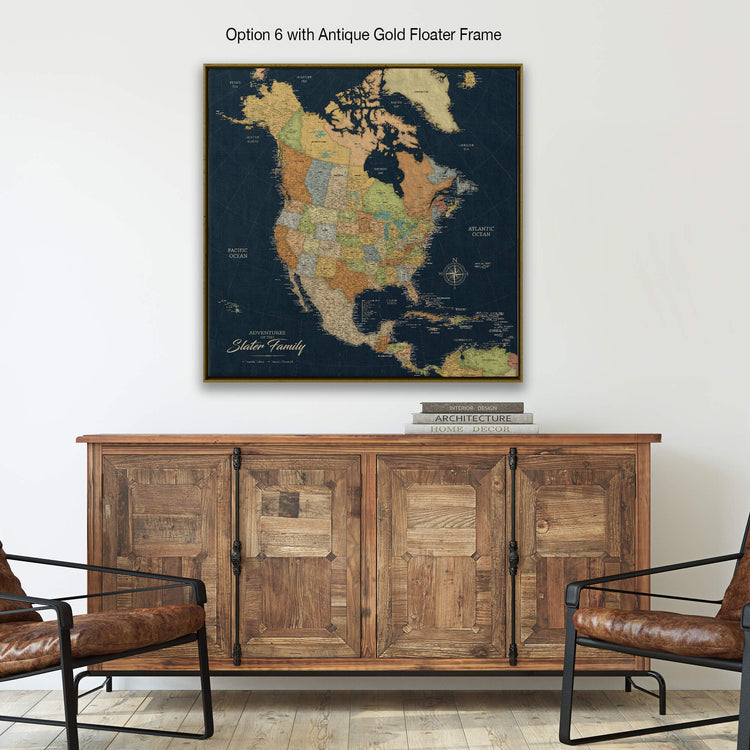a large, antique gold-framed map of North America hanging on a wall above a wooden cabinet.