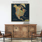 a large, antique gold-framed map of North America hanging on a wall above a wooden cabinet.