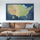 a large, detailed map of the United States hanging on a wall above a brown leather couch.