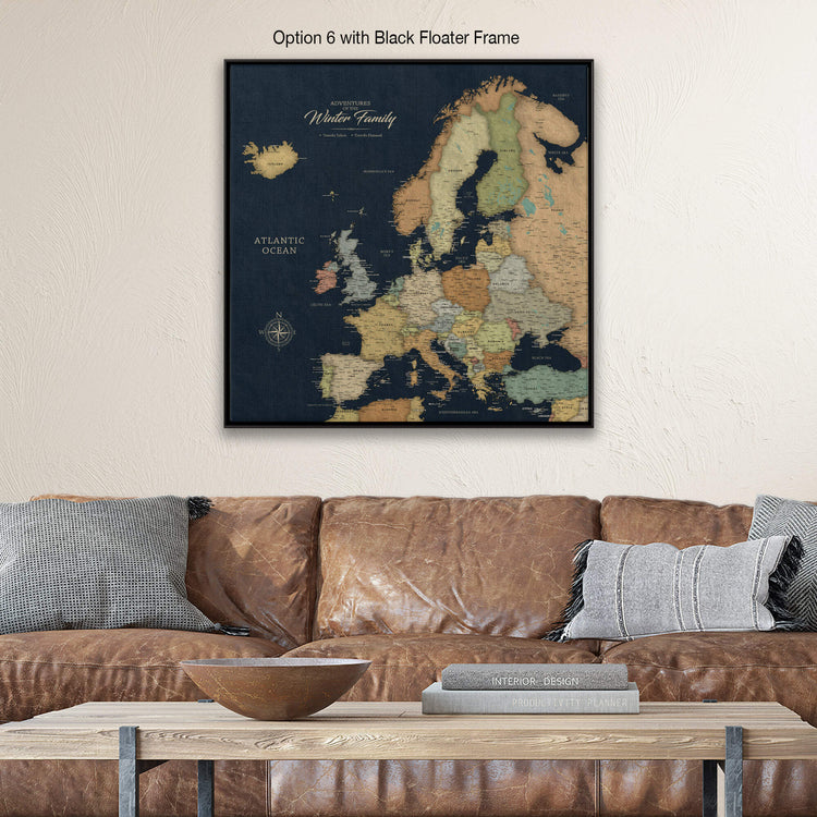 a large, detailed map of Europe displayed on a wall above a brown leather couch.