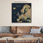 a large, detailed map of Europe displayed on a wall above a brown leather couch.