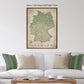 a living room with a white sofa and a wooden coffee table. Above the sofa, there is a framed map of Germany hanging on the wall.