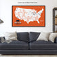 A custom map with a black floating frame is displayed on the wall above a gray couch with white pillows.