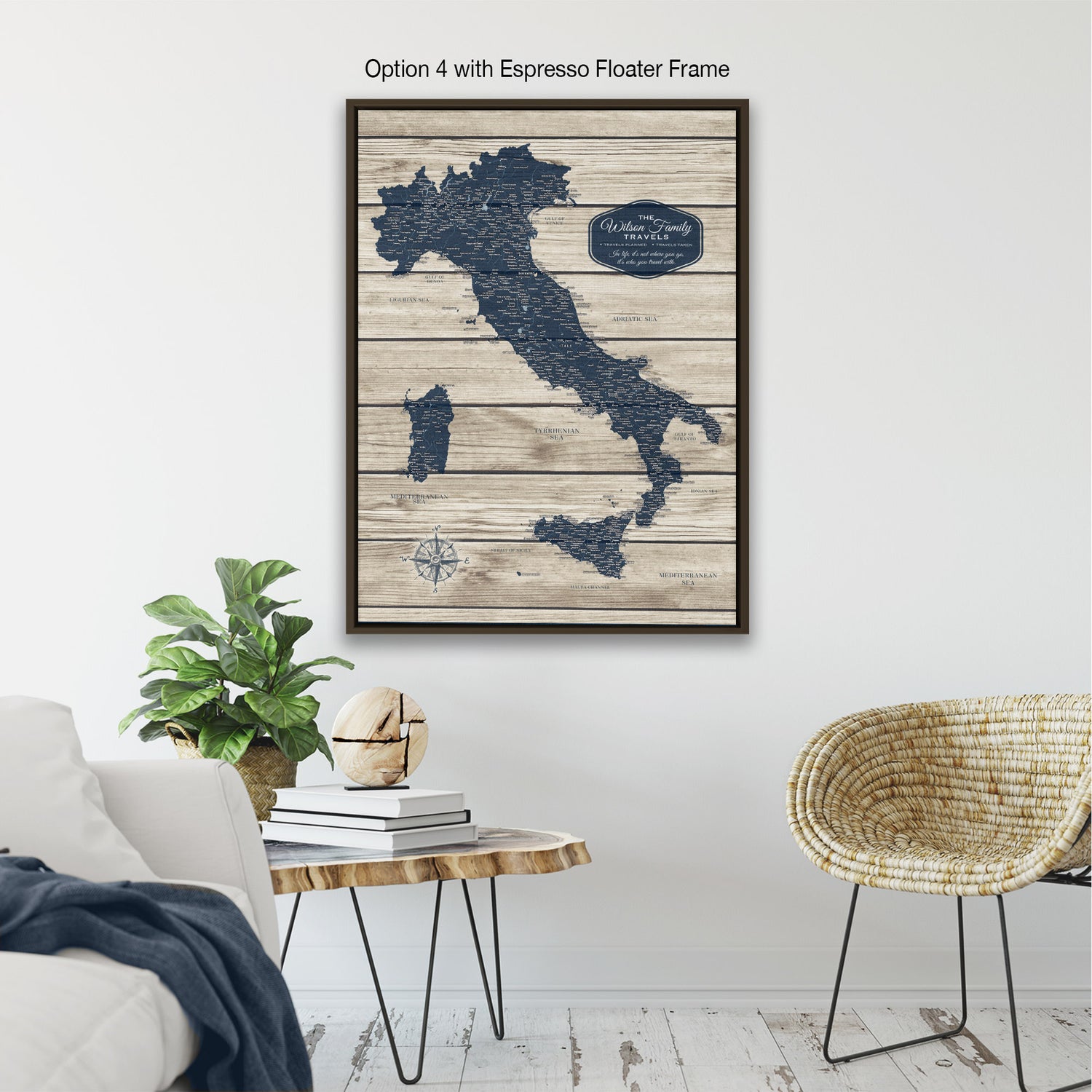 a living room with a wooden coffee table, a wicker chair, and a potted plant. Above the coffee table, there is a framed map of Italy hanging on the wall.