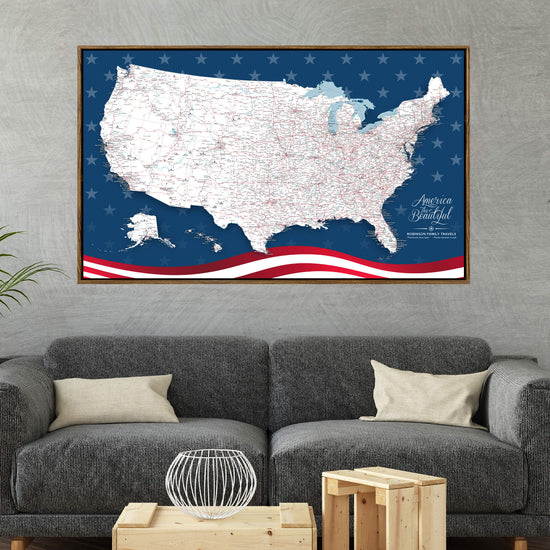 a large, detailed map of the United States with an American flag design on the border. The map is displayed on a wall above a gray couch with two pillows.