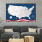 a large, detailed map of the United States with an American flag design on the border. The map is displayed on a wall above a gray couch with two pillows.