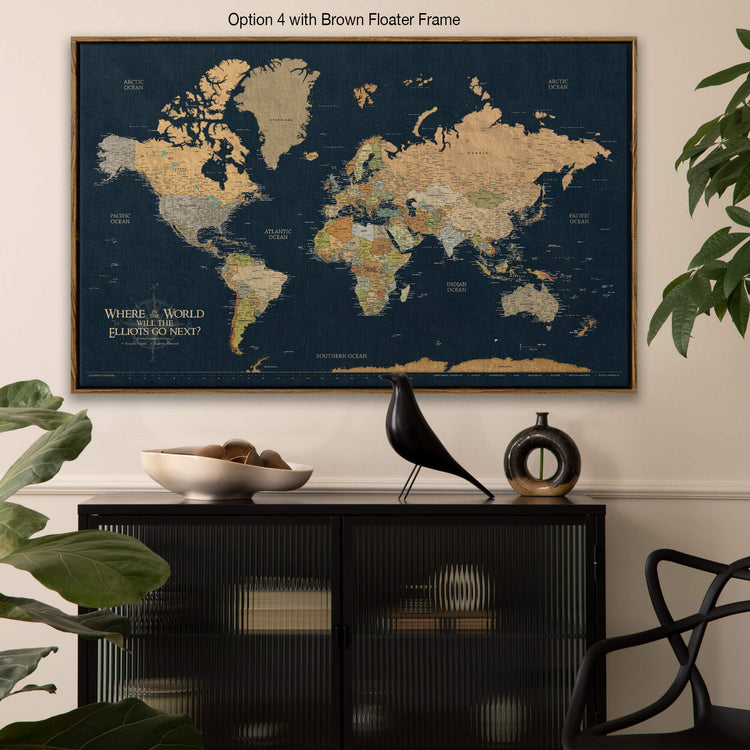 a large world map with a brown frame, hanging on a wall above a black cabinet with a bird figurine on top.