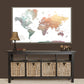 a large world map displayed on a wall above a black console table with storage baskets below it.