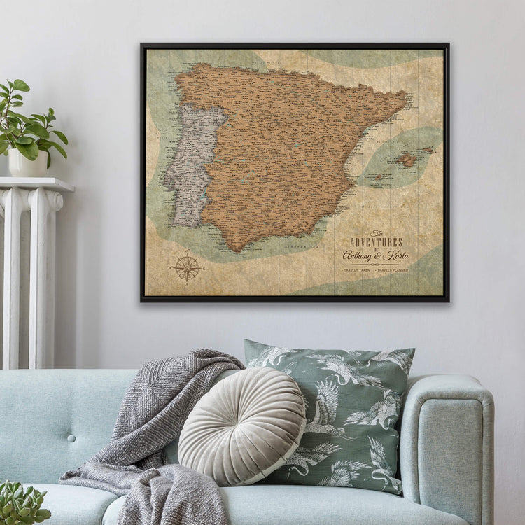 a large framed map of Spain hanging on a wall above a couch with decorative pillows.