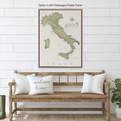 a framed map of Italy hanging on a white wall above a wooden bench with pillows.