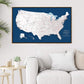 a large, detailed map of the United States hanging on a wall above a white couch in a living room setting.