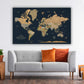 a large world map poster hanging on a wall above a gray sofa with orange and red throw pillows.