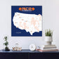 a wall-mounted map of the United States with various locations marked, including a football stadium. Below the map, there is a collection of decorative items such as a glass dome, a clock, and a stack of books.