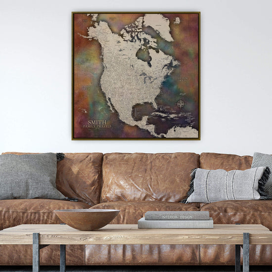 a large, colorful map of North America hanging on a wall above a brown leather couch.