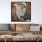 a large, colorful map of North America hanging on a wall above a brown leather couch.