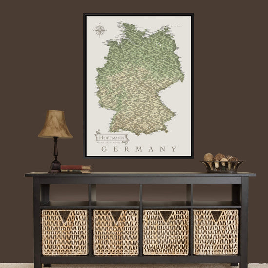a large framed map of Germany hanging on a wall above a black console table with woven baskets below it.