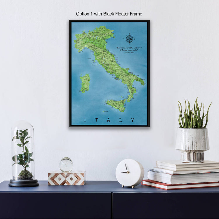 a framed map of Italy hanging on a wall, with a glass dome containing a plant, a white clock, and a stack of books below it.