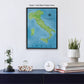 a framed map of Italy hanging on a wall, with a glass dome containing a plant, a white clock, and a stack of books below it.