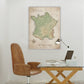 a map of France hanging on a wall, with a desk and chair in the foreground.