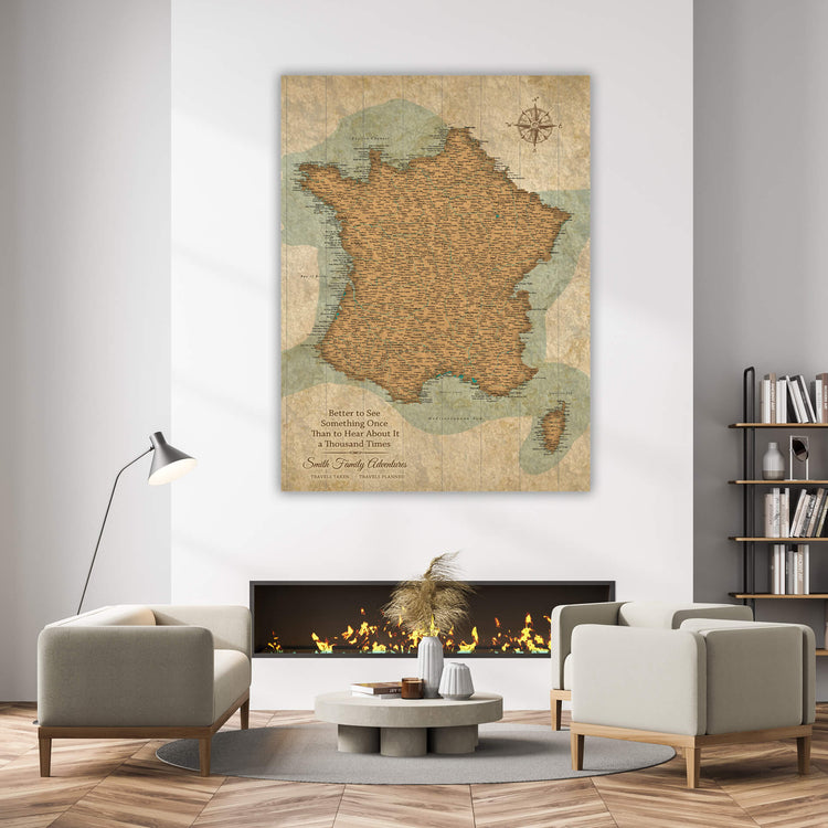 a living room with a large map of France hanging on the wall above a fireplace. The room has a cozy and inviting atmosphere, with a coffee table in the center and two chairs placed around it. There are also several books and decorative items in the room, creating a comfortable and personalized space.