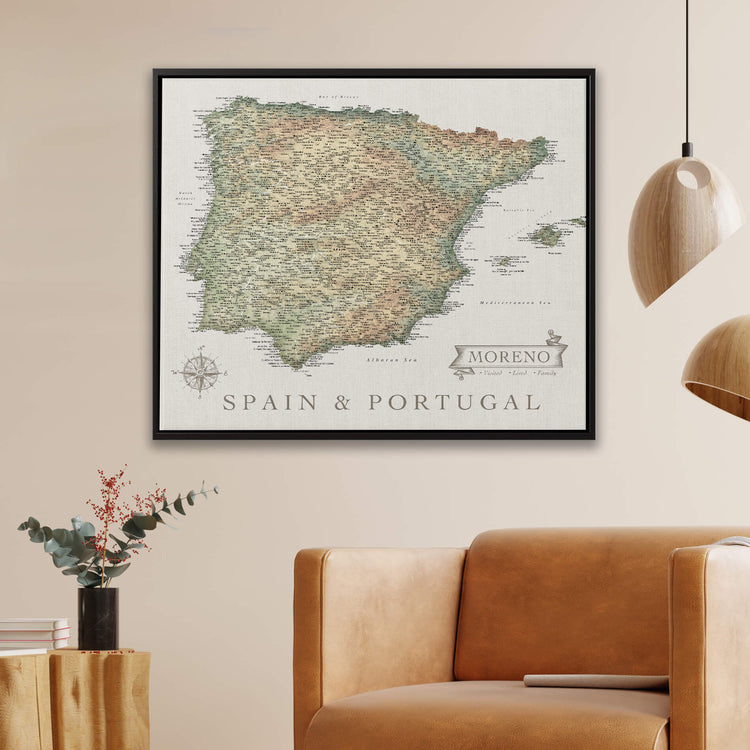 a framed map of Spain and Portugal hanging on a wall, with a brown leather armchair in the foreground.