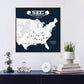 a framed map of the United States with various locations marked, along with a football helmet and a football. The map is set against a navy blue background, and there is a clock and a glass dome on a shelf below the frame.