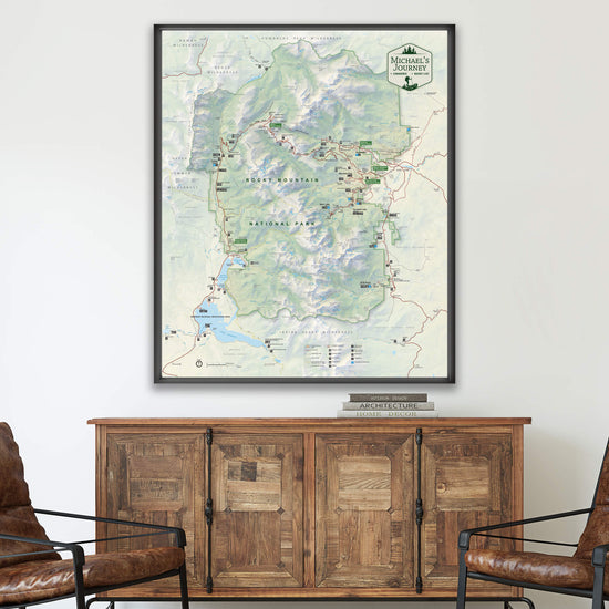 a large framed map of the outdoors, likely a hiking trail map, hanging on a wall above a wooden cabinet.