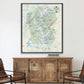 a large framed map of the outdoors, likely a hiking trail map, hanging on a wall above a wooden cabinet.