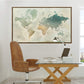 a large world map hanging on a wall above a wooden desk with a laptop, books, and a lamp.